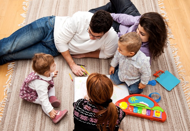 family group of five on the floor - two babies and three adults in the middle of a conversation.